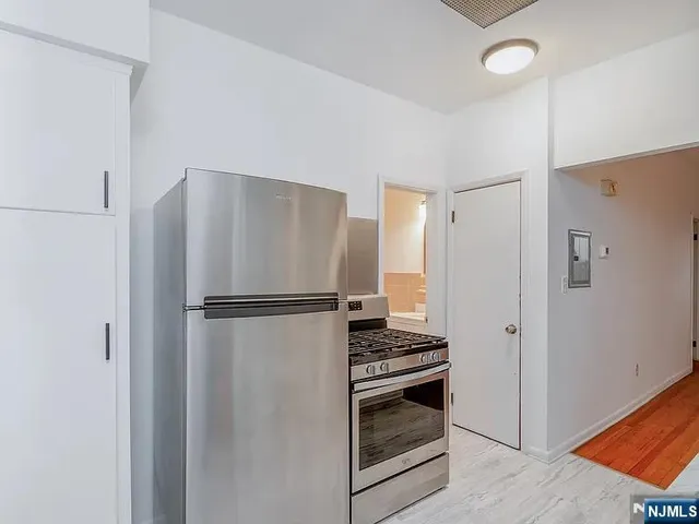 a white refrigerator freezer and a stove sitting inside of a kitchen
