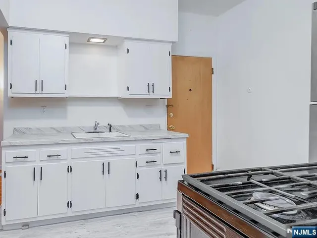 a stove top oven sitting inside of a kitchen