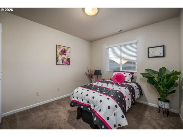 a bedroom with a bed and a potted plant