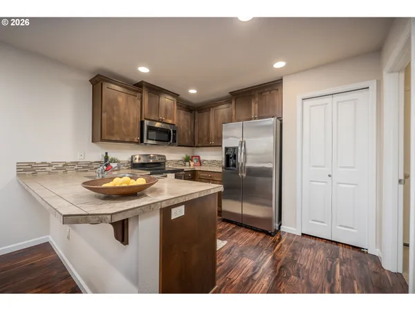 a kitchen with stainless steel appliances granite countertop a sink stove and refrigerator