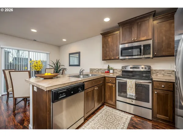 a kitchen with stainless steel appliances granite countertop a stove a sink and a microwave