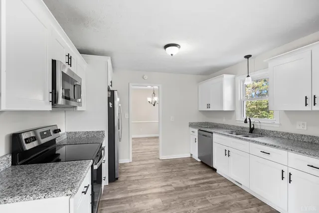 a kitchen with granite countertop a sink white cabinets and a granite counter tops