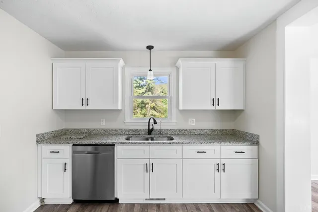 a kitchen with stainless steel appliances white cabinets and a stove top oven