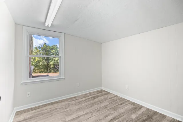 a view of a hallway with wooden floor and closet area