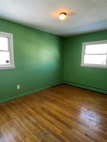 an empty room with a hard wood floor and a window