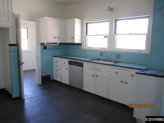 137 Burns Street Reno, NV 89502 - Photo 2 of 9 a kitchen with granite countertop white cabinets sink and window