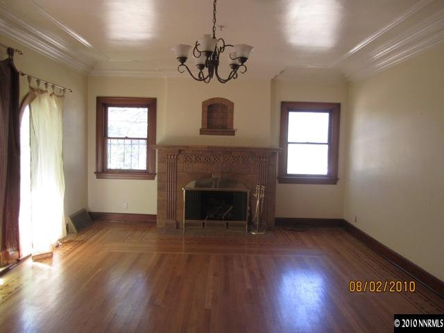137 Burns Street Reno, NV 89502 - Photo 3 of 9 a view of an empty room with wooden floor fireplace and a window