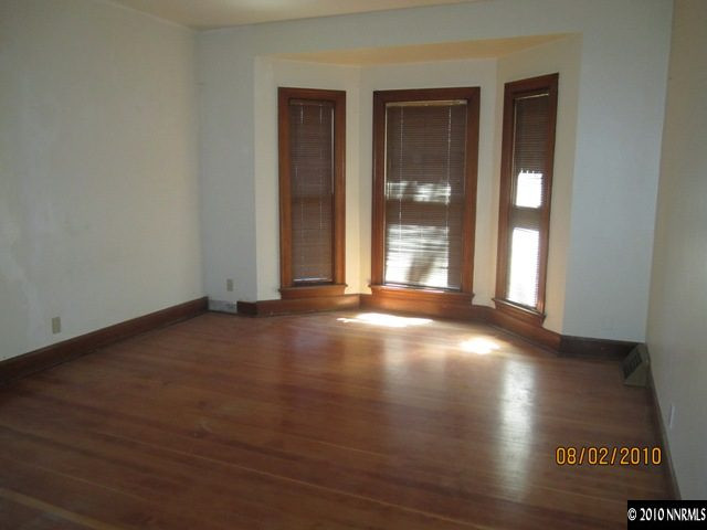 137 Burns Street Reno, NV 89502 - Photo 5 of 9 an empty room with wooden floor and windows