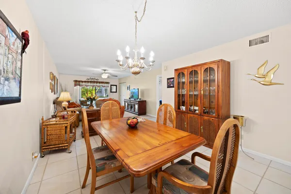 a living room with furniture a chandelier and a dining table