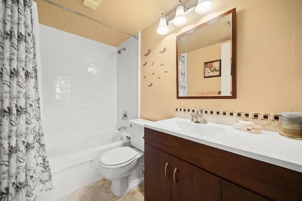 a bathroom with a granite countertop toilet a sink and a mirror