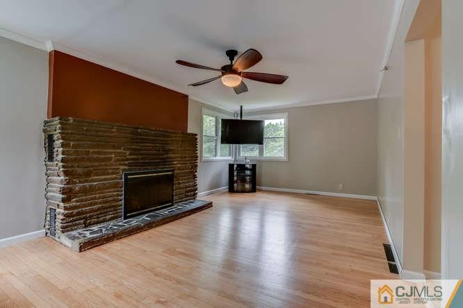 139 Milltown Road East Brunswick, NJ 08816 - Photo 8 of 15 a living room with wooden floor and a fireplace