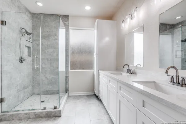 a bathroom with a shower sink and mirror