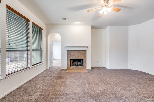 a view of an empty room with a fireplace and a window