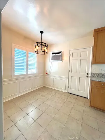 a view of a kitchen with kitchen island granite countertop white cabinets and window