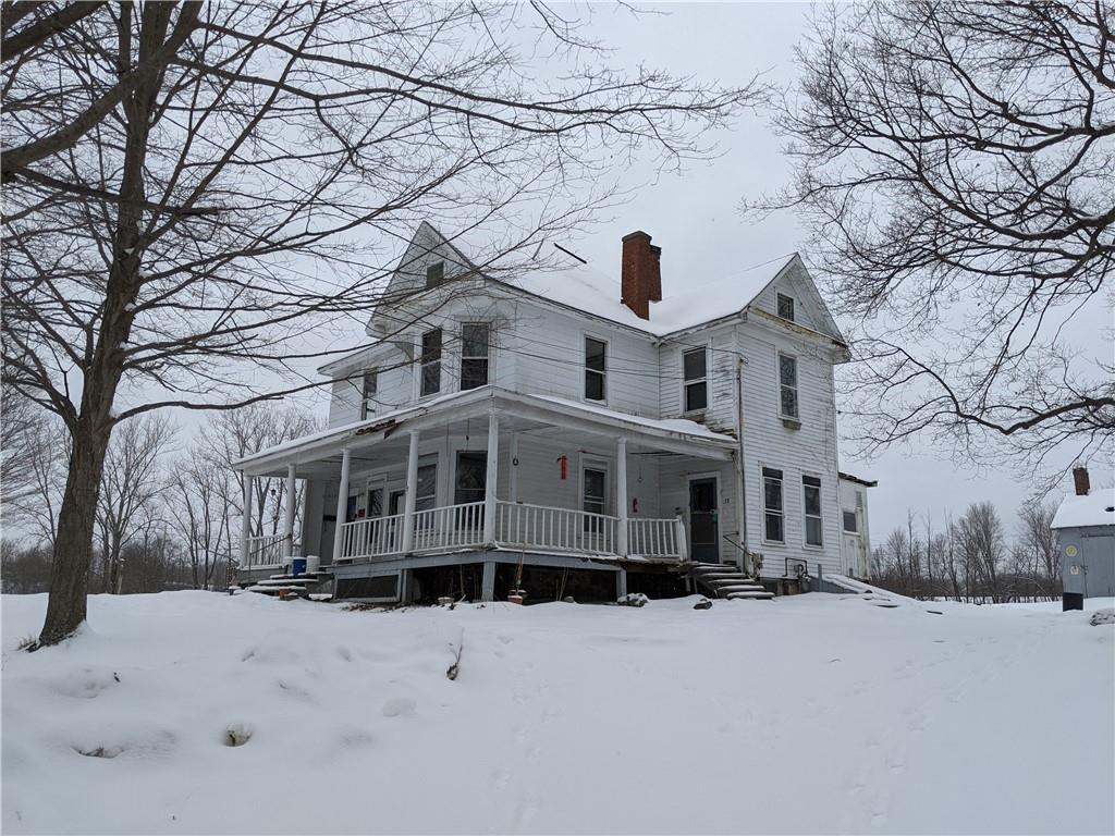 a front view of a house with a yard covered in snow