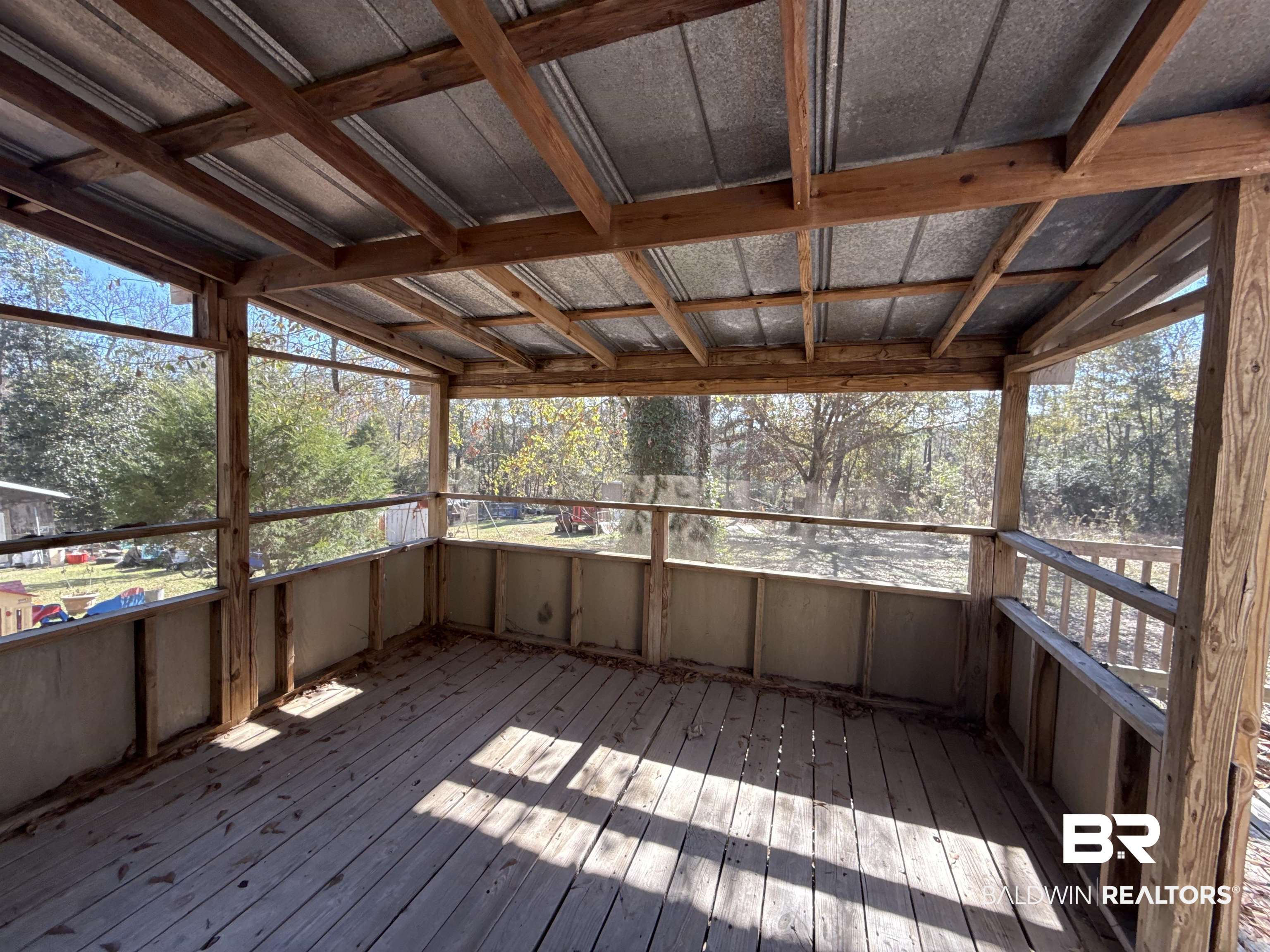 32 Slate Street Atmore, AL 36502 - Photo 14 of 16 Unfurnished sunroom with a wooden deck and healthy amount of natural light