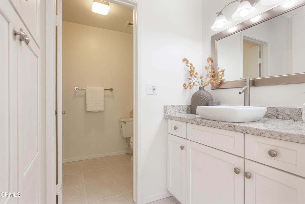 17516 Via Calma, Unit 39 Tustin, CA 92780 - Photo 15 of 29 a bathroom with a granite countertop sink a mirror and a shower