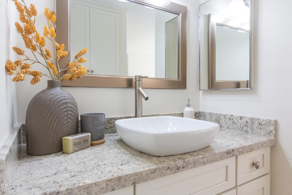 17516 Via Calma, Unit 39 Tustin, CA 92780 - Photo 16 of 29 a bathroom with a granite countertop sink and a mirror