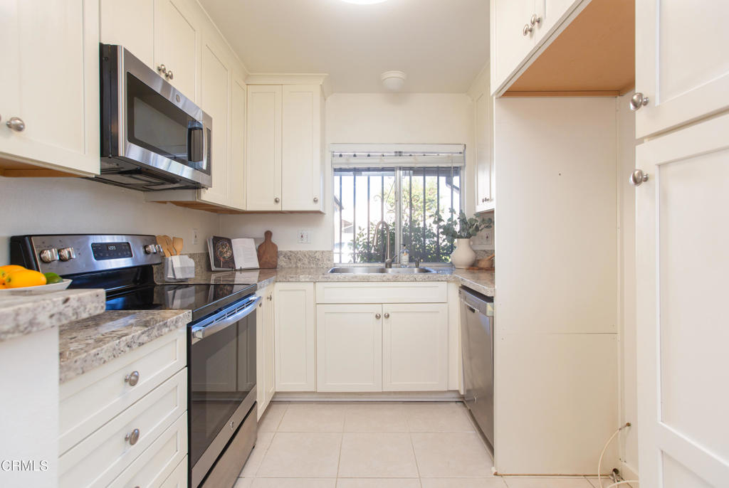 17516 Via Calma, Unit 39 Tustin, CA 92780 - Photo 8 of 29 a kitchen with white cabinets and appliances