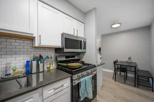 a kitchen with granite countertop a stove a sink and a microwave