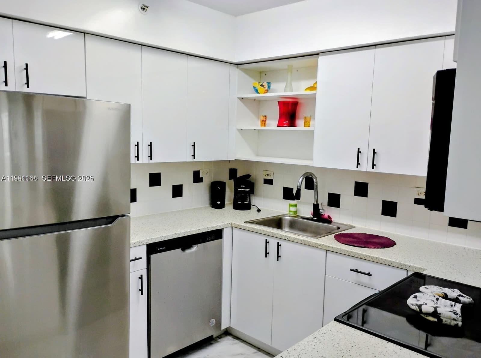 1500 Bay Road, Unit 854S Miami Beach, FL 33139 - Photo 14 of 20 a kitchen with a sink a refrigerator and cabinets