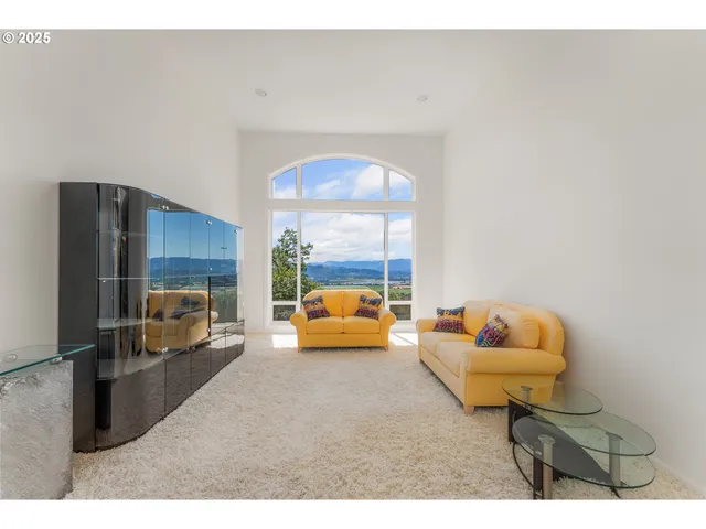 a bedroom with furniture and a large window