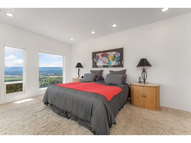 a spacious bedroom with a bed and a flat screen tv