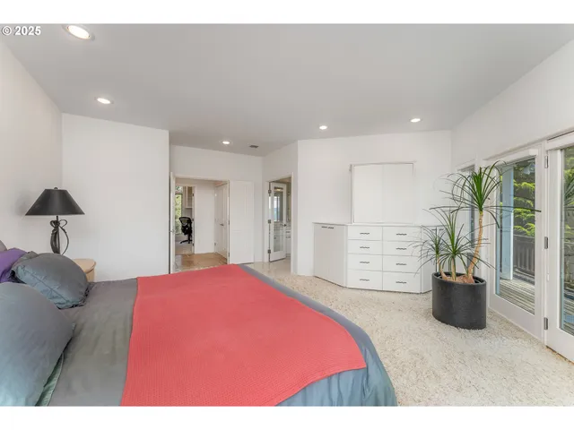 a bedroom with a large bed and a potted plant