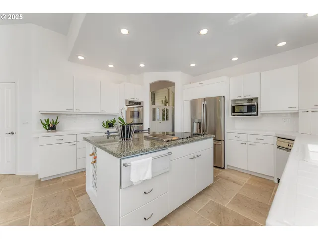 a kitchen with white cabinets appliances and sink
