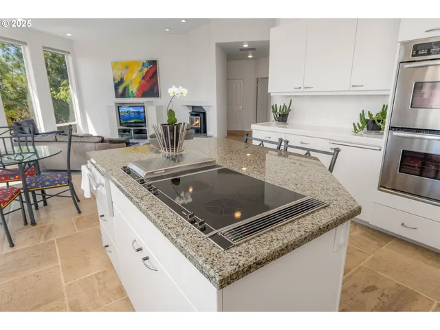 a kitchen with stainless steel appliances granite countertop a sink a stove and a refrigerator