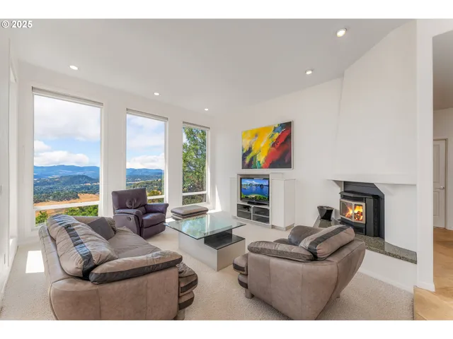 a living room with fireplace furniture and a large window