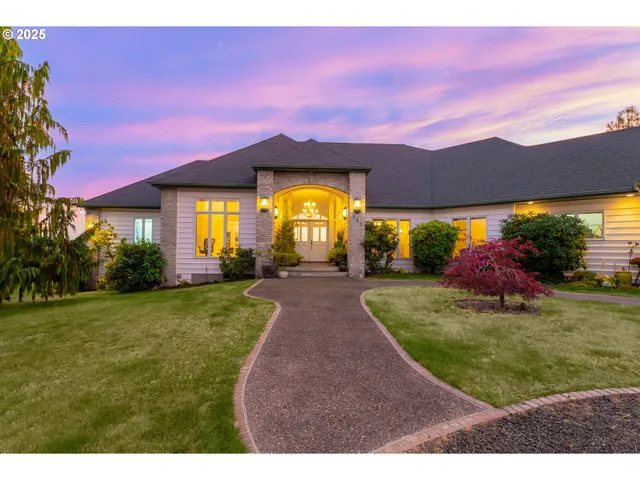 a view of a big house with a big yard and potted plants