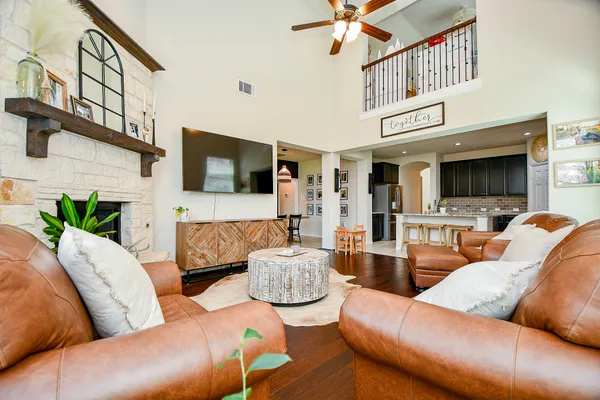 a living room with furniture a flat screen tv and kitchen view