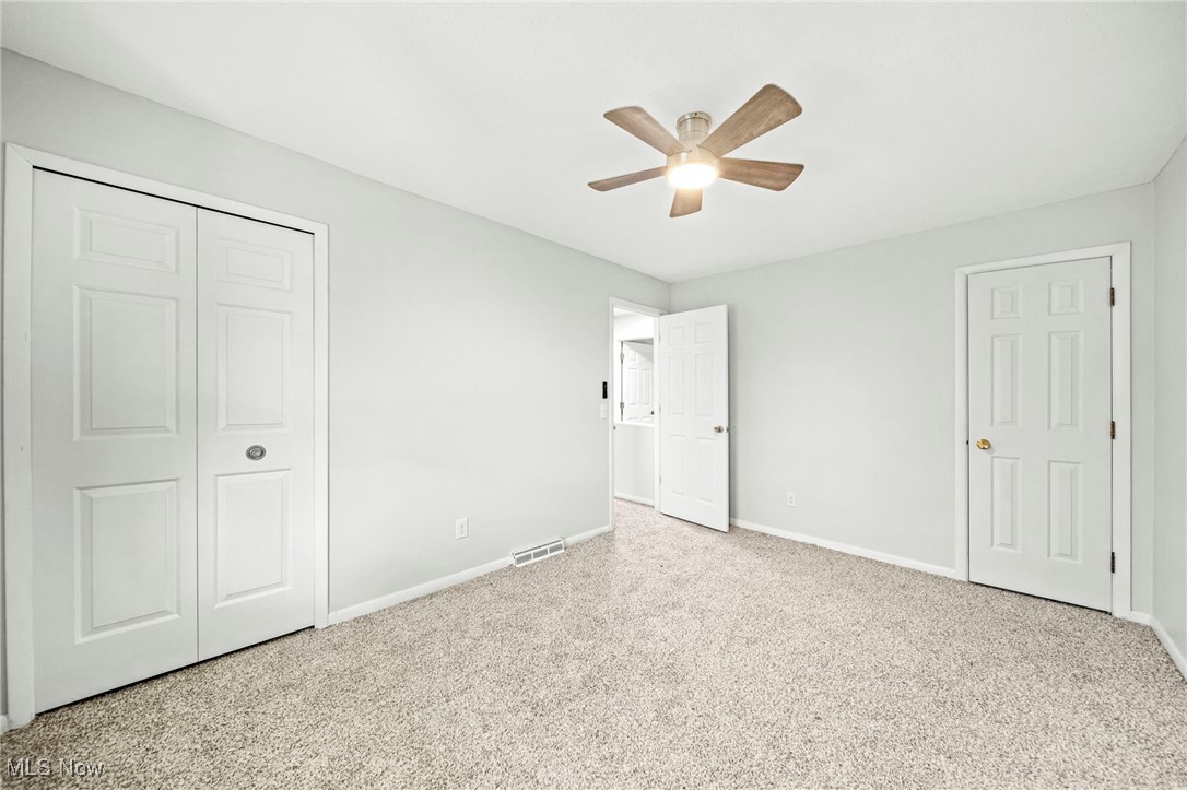 91 Paradise Road Painesville, OH 44077 - Photo 23 of 39 Unfurnished bedroom with carpet flooring, a ceiling fan, and a closet