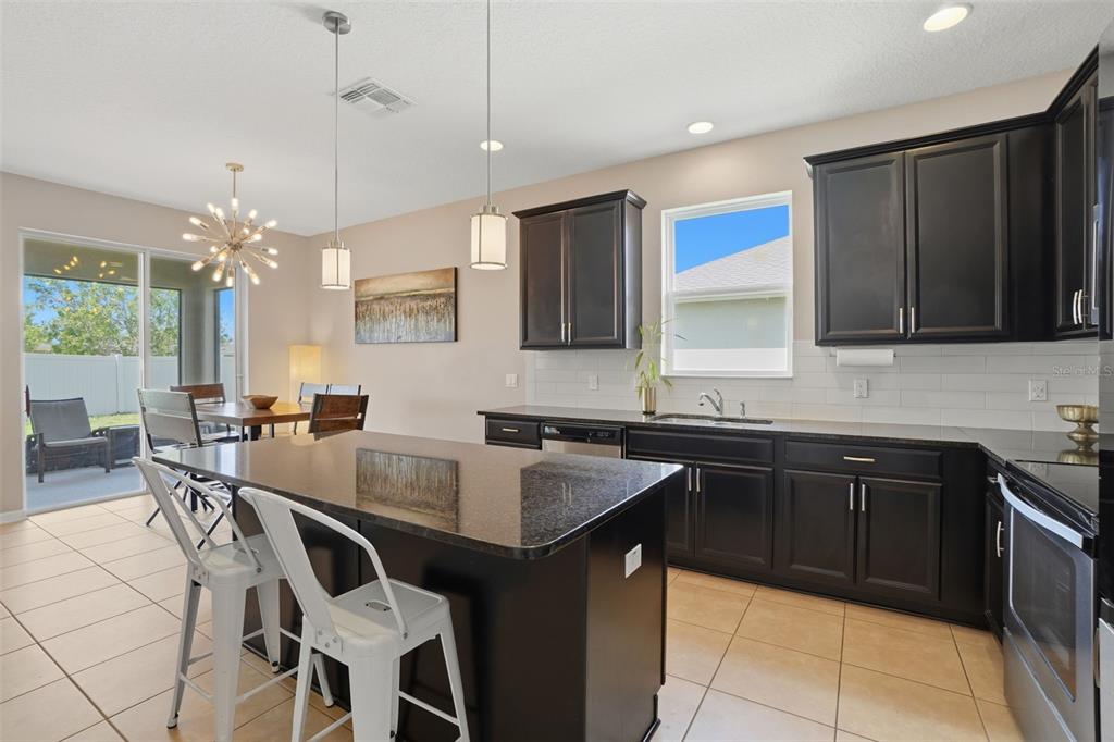 3933 Wind Dancer Circle St. Cloud, FL 34772 - Photo 11 of 35 a kitchen with a table chairs sink and cabinets