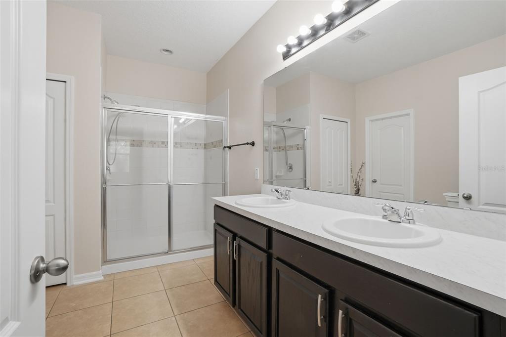3933 Wind Dancer Circle St. Cloud, FL 34772 - Photo 19 of 35 a bathroom with a sink double vanity and a mirror