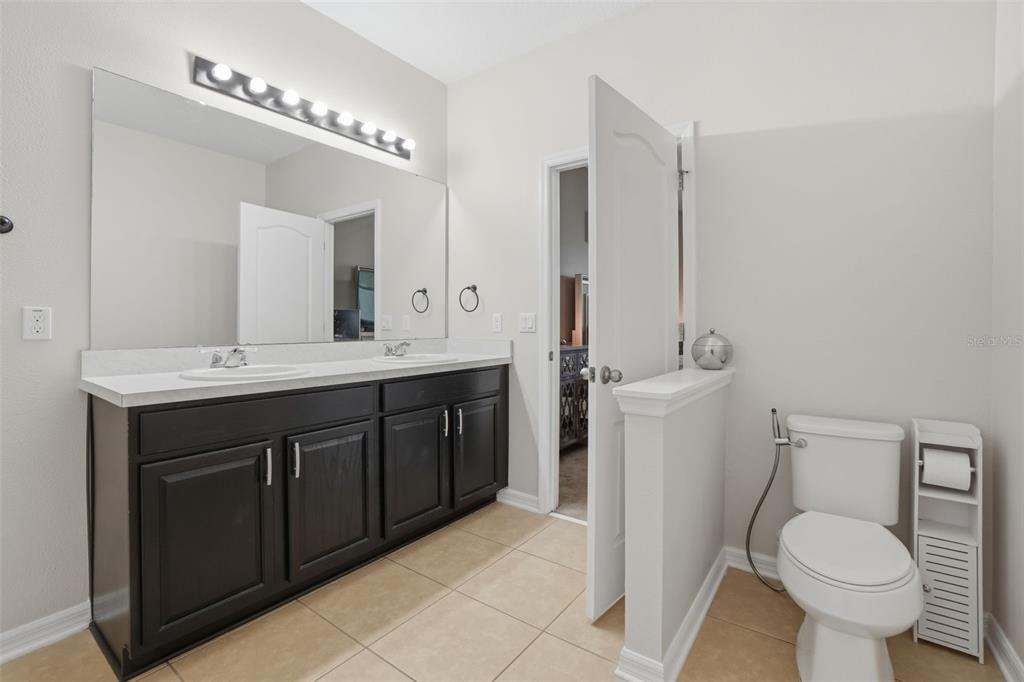 3933 Wind Dancer Circle St. Cloud, FL 34772 - Photo 20 of 35 a bathroom with a sink toilet and mirror