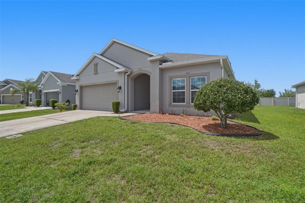 3933 Wind Dancer Circle St. Cloud, FL 34772 - Photo 2 of 35 a front view of a house with a yard