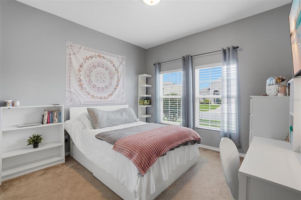 3933 Wind Dancer Circle St. Cloud, FL 34772 - Photo 21 of 35 a bedroom with a bed painting on wall and a large window