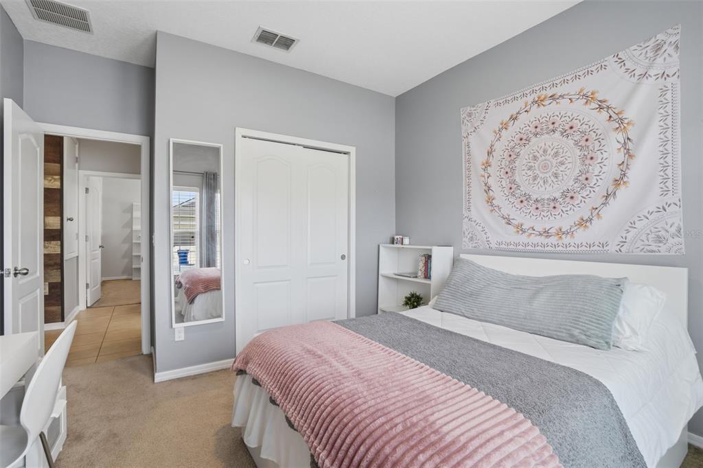 3933 Wind Dancer Circle St. Cloud, FL 34772 - Photo 22 of 35 a bedroom with a bed and a painting on the wall