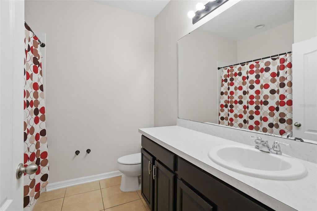 3933 Wind Dancer Circle St. Cloud, FL 34772 - Photo 23 of 35 a bathroom with a sink and a mirror