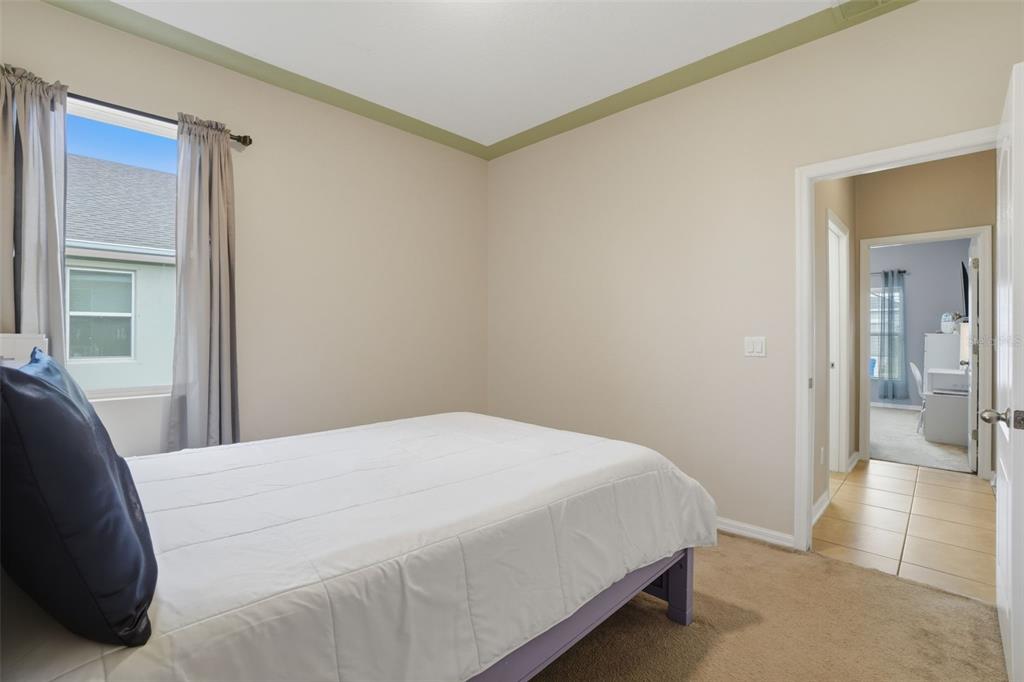 3933 Wind Dancer Circle St. Cloud, FL 34772 - Photo 25 of 35 a bedroom with a bed and glass door