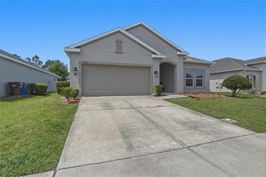 3933 Wind Dancer Circle St. Cloud, FL 34772 - Photo 3 of 35 a front view of a house with a yard and garage
