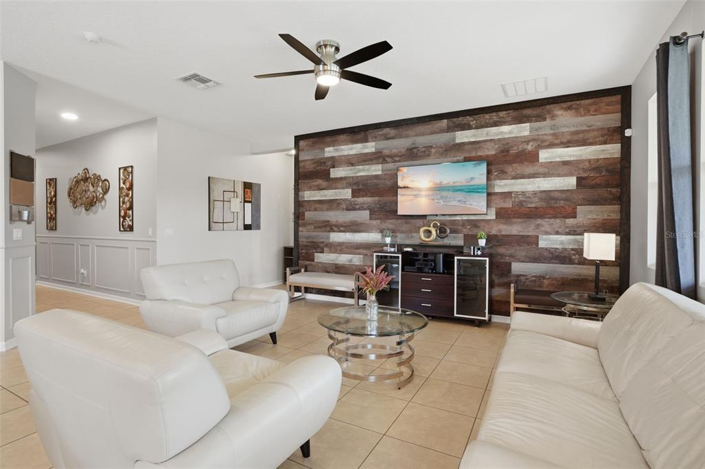 3933 Wind Dancer Circle St. Cloud, FL 34772 - Photo 6 of 35 a living room with furniture a flat screen tv and a large window