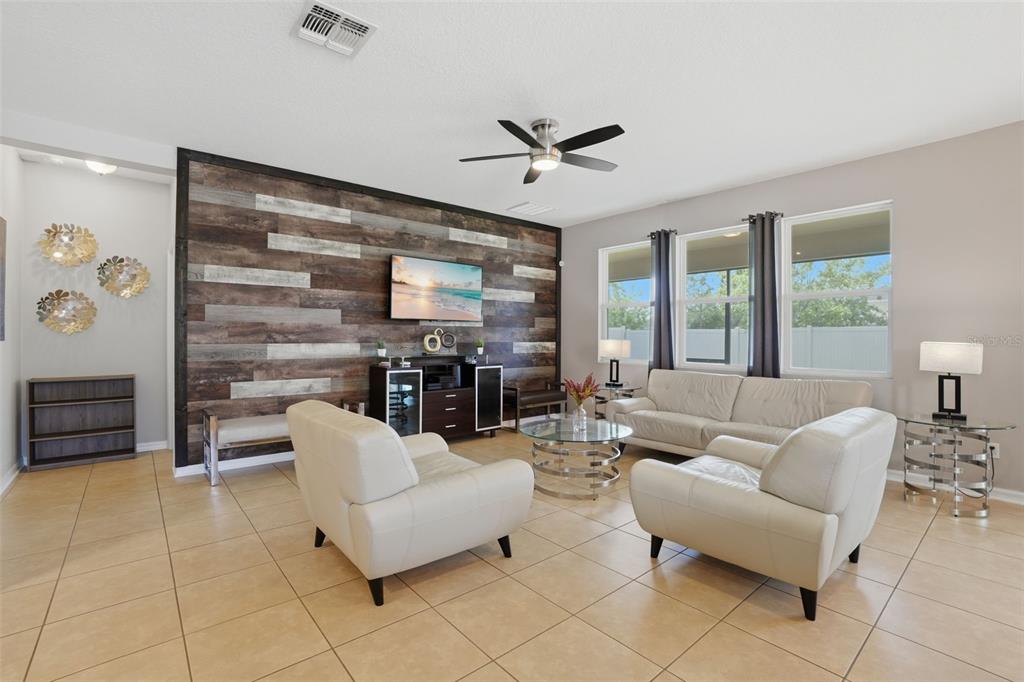 3933 Wind Dancer Circle St. Cloud, FL 34772 - Photo 7 of 35 a living room with furniture a ceiling fan and a large window