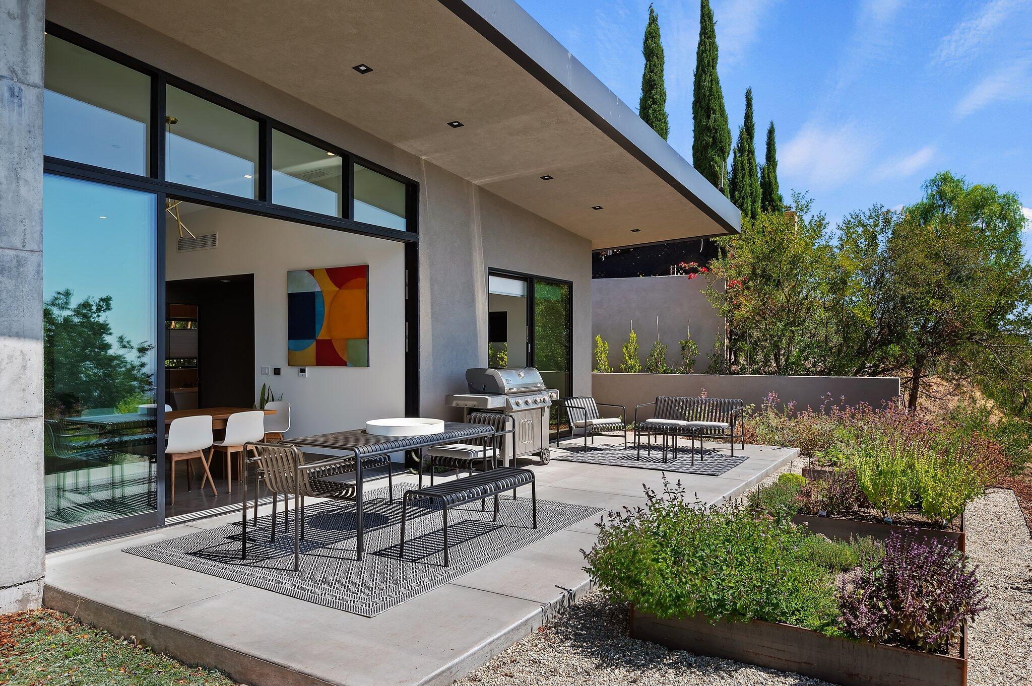 2805 Spyglass Ridge Road Santa Barbara, CA 93105 - Photo 60 of 67 a view of a patio with table and chairs potted plants and floor to ceiling window