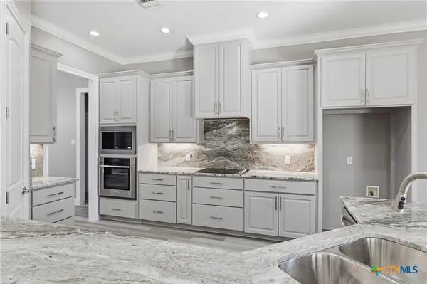 a bathroom with a granite countertop tub sink a mirror and a shower