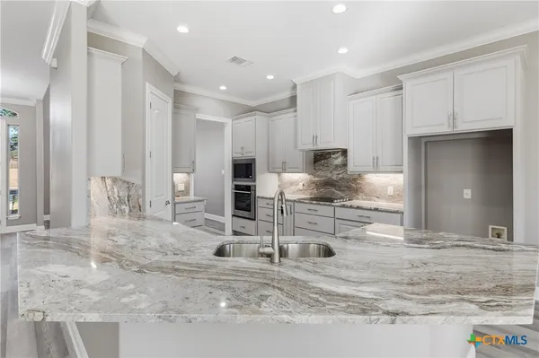 a bathroom with a granite countertop sink double vanity and a mirror