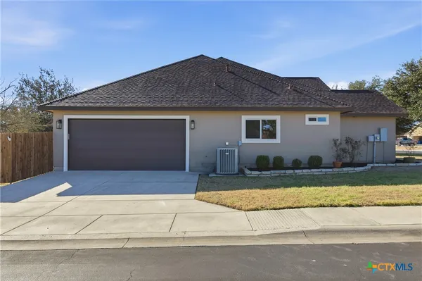 an empty room with wooden floor fireplace and windows