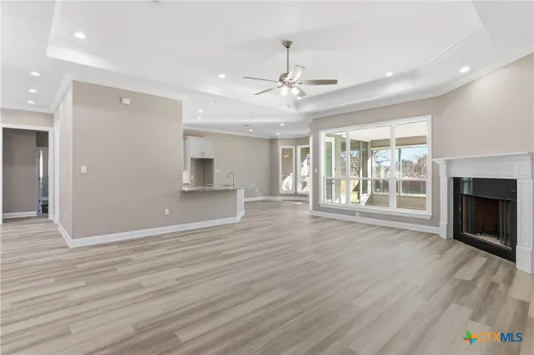 a view of an empty room with a window and a dresser
